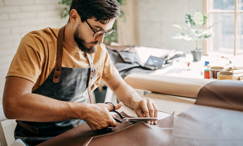 small business owner cutting leather